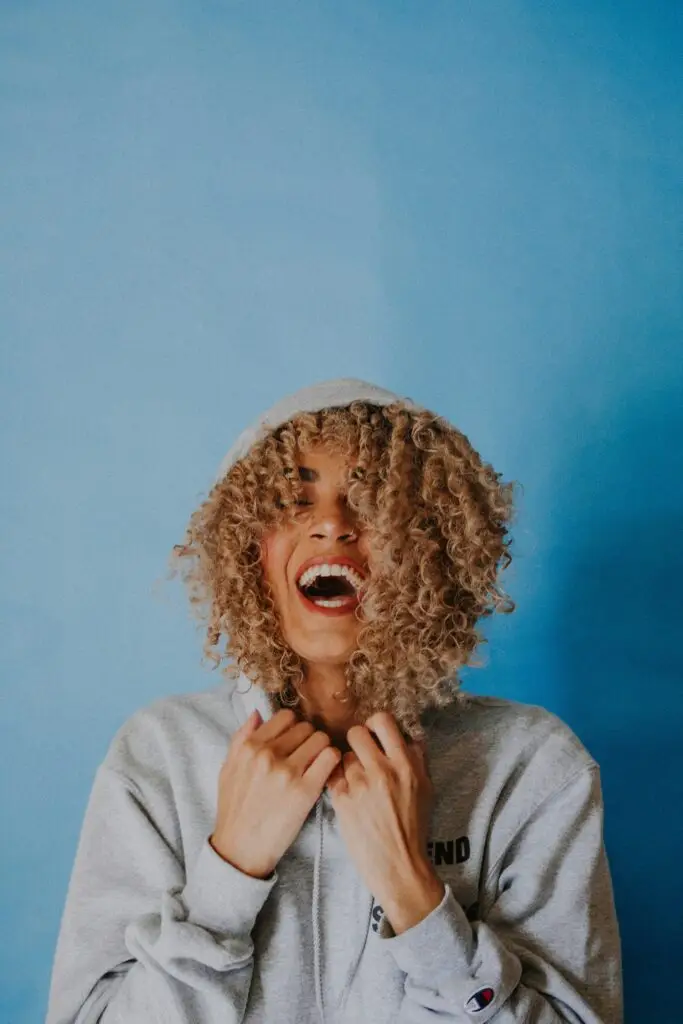 Woman laughing wearing a sweater