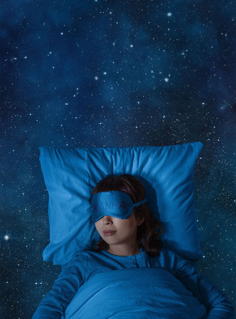Image of woman sleeping on a blue pillow with an eye mask on