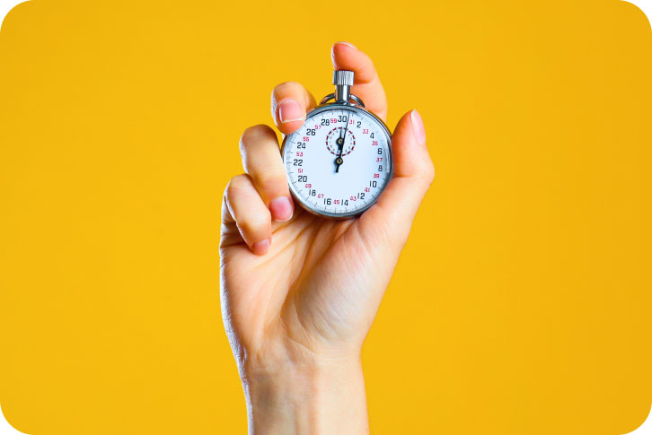 Image of hand holding a stopwatch on a yellow background